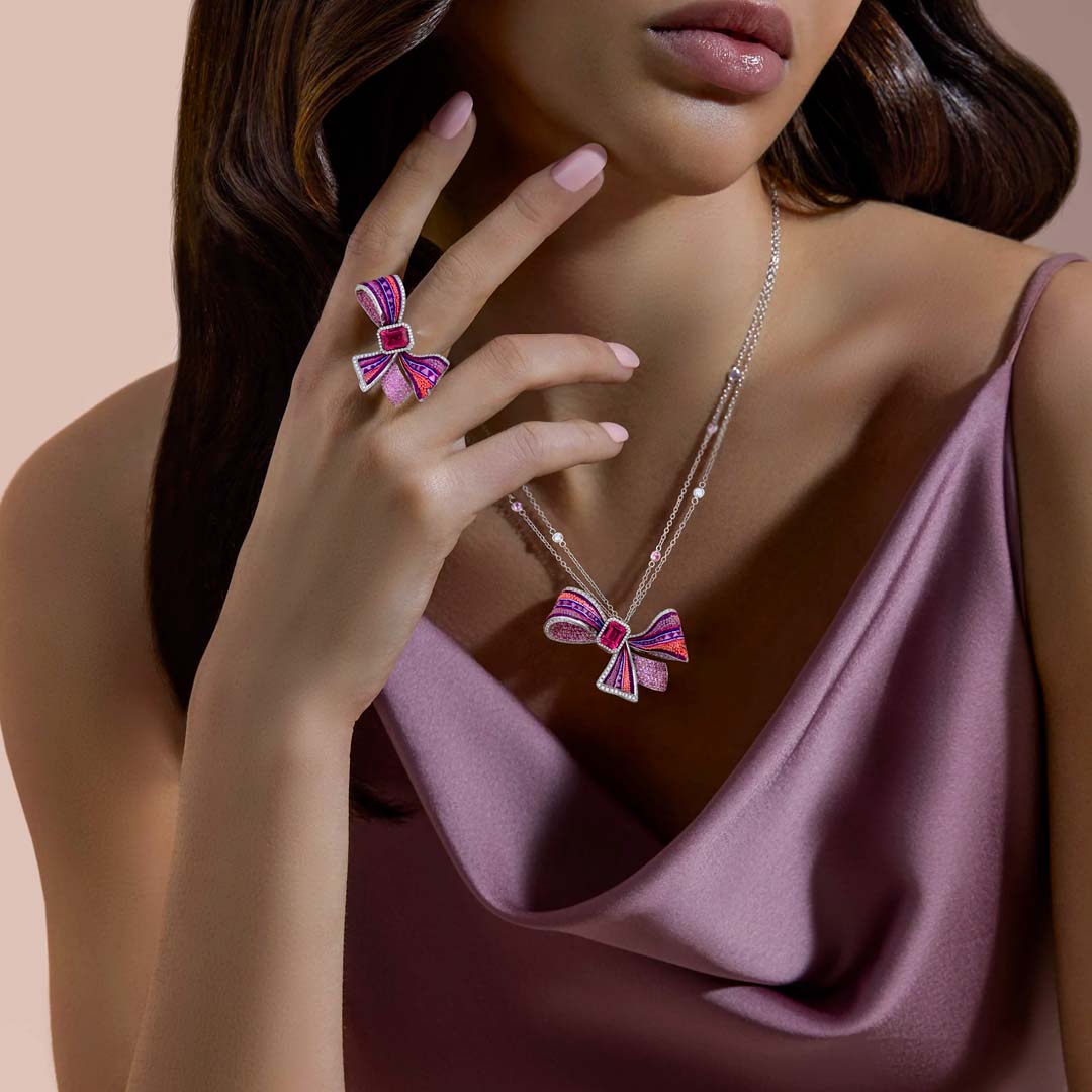 Woman wearing a Sicis Jewels Pink Ribbon necklace and ring