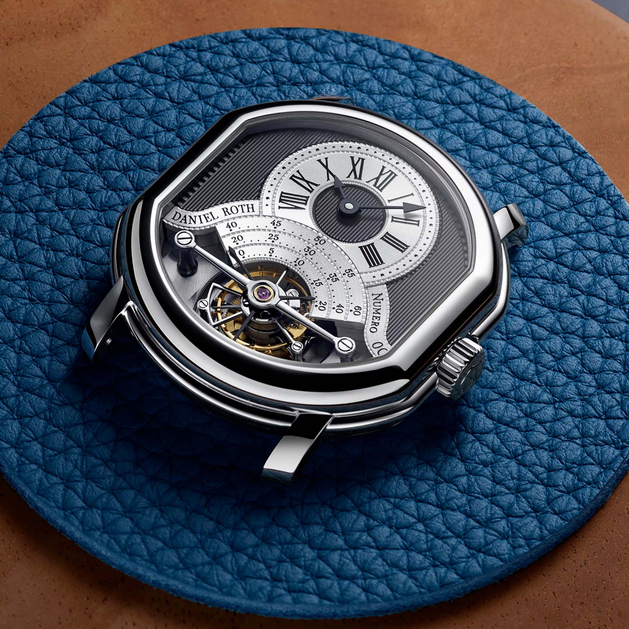 Elegant and technically refined, the Tourbillon Platinum showcases a platinum case, a hand engraved guilloché dial and the signature in house DR001 shaped movement.