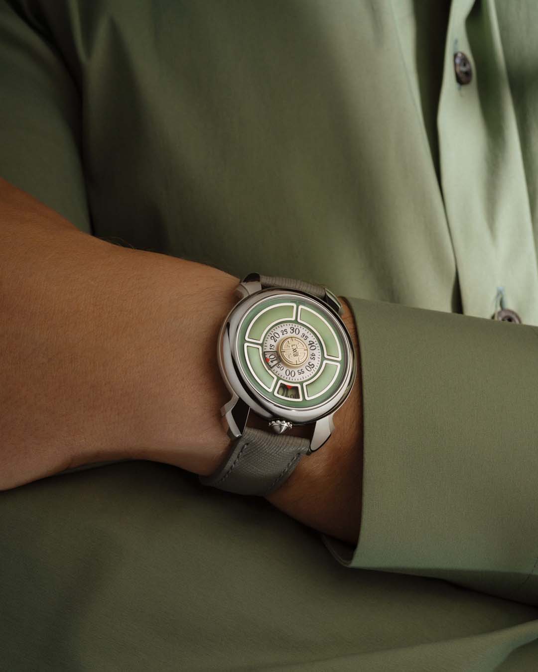 Watch with a green face on a wrist, wearing a green shirt