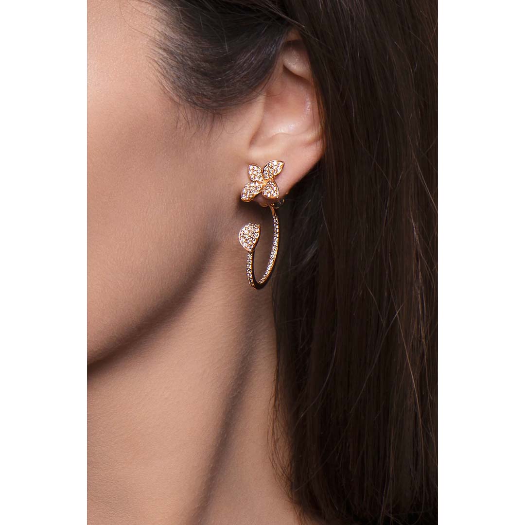 Close-up of a woman wearing a gold butterfly earring with a blurred background